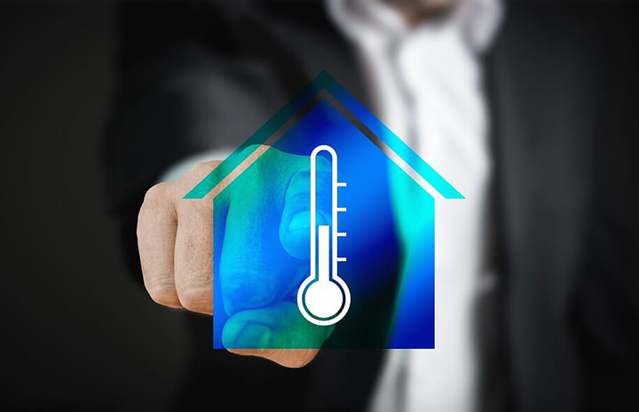 Man pointing at icon of home with thermometer