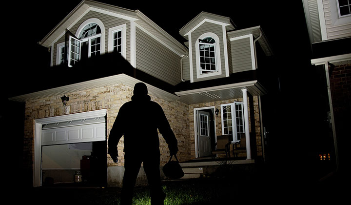 silhouette of burglar in front of a house