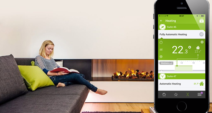 Person in font of fireplace with loxone heating app showing