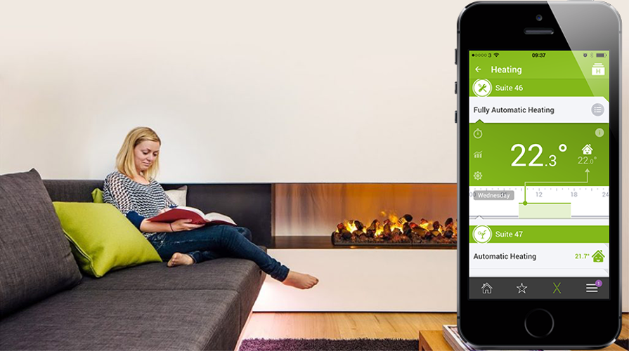 Person in font of fireplace with loxone heating app showing