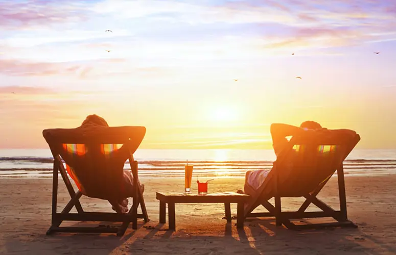 Couple relaxing on a beach with cocktails