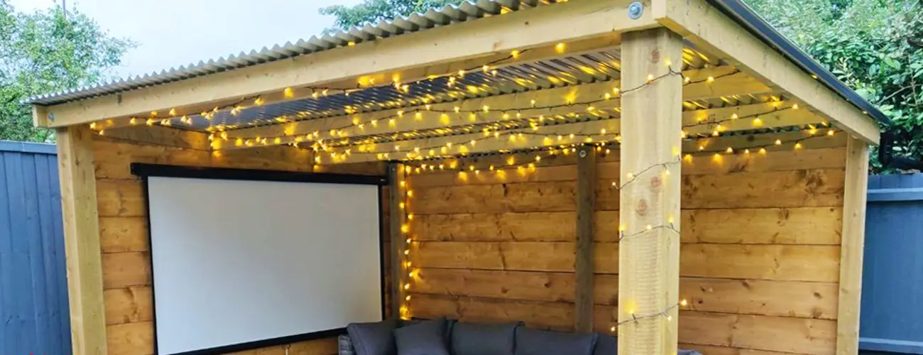 Outdoor projector screen in a small log cabin