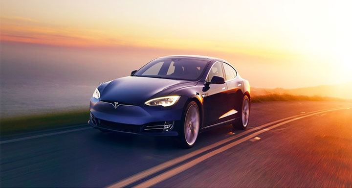 Tesla on road with sunset